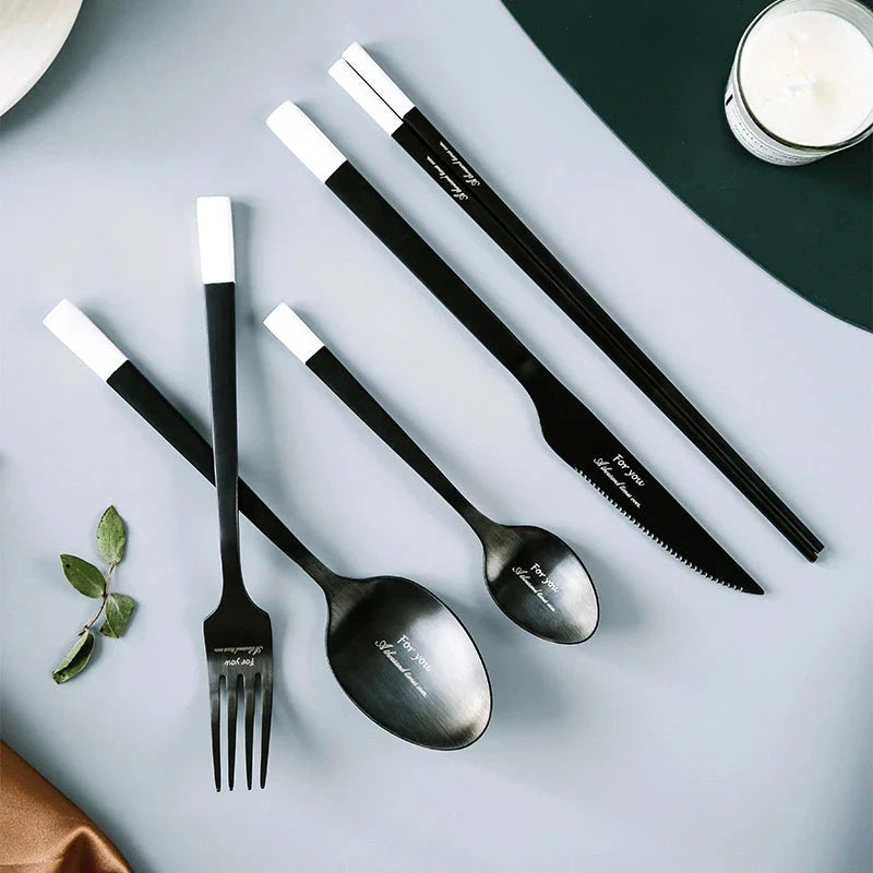 Elegant Nordic stainless steel cutlery set with sleek black and white design, including tea spoon, dinner spoon, dinner fork, dinner knife, and chopsticks