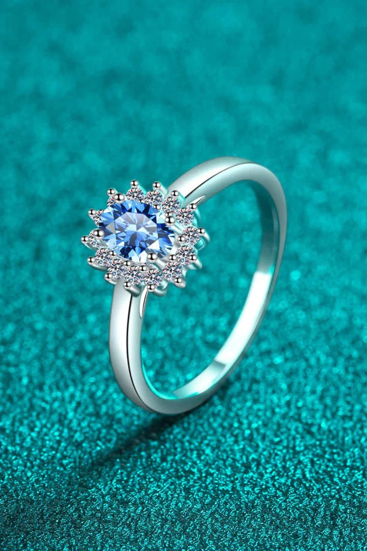 A close-up of a minimalist, polished 925 sterling silver ring with a dazzling moissanite centre stone