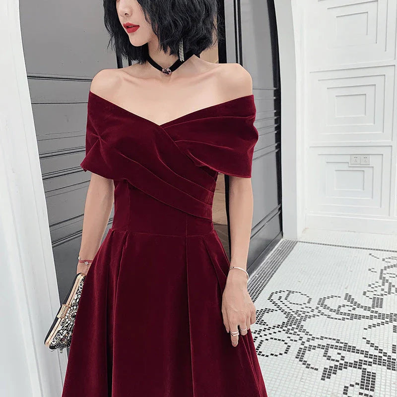 Off-shoulder wine red bridal dress with long, flowing skirt and tight waist for a sophisticated, elegant look