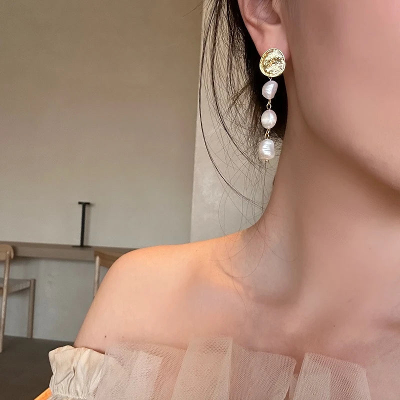 Elegant pearl and gold plated earrings with a long, eye-catching design