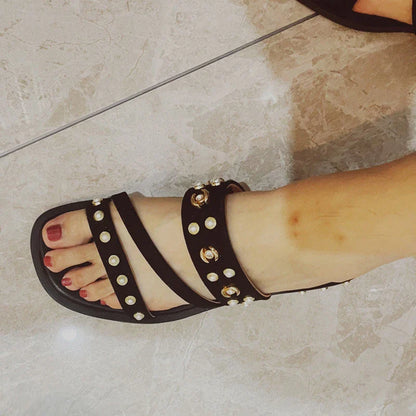 Black flat sandals with orange accents, inspired by the Roman Holiday style, suitable for women