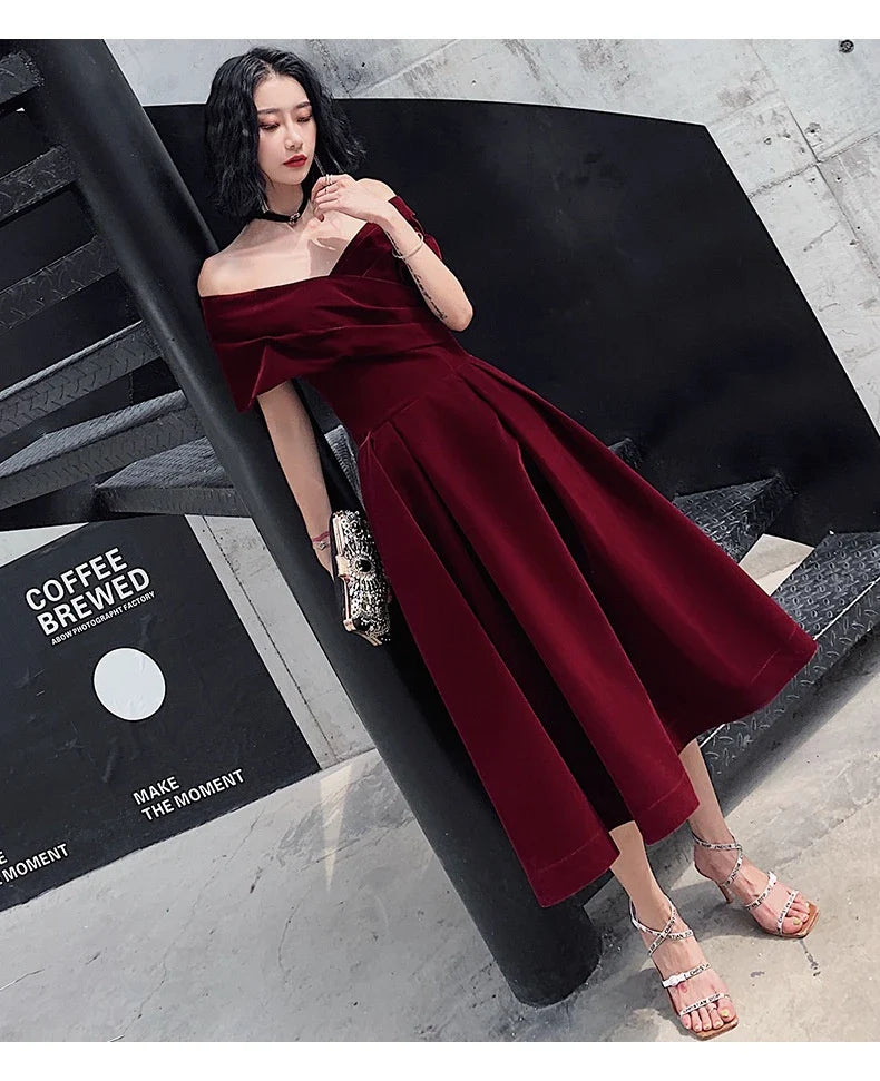 Off-shoulder wine red bridal dress with long, flowing skirt and tight waist for a sophisticated, elegant look
