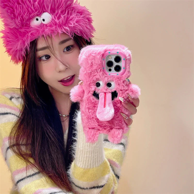 Playful plush phone case with cheeky cartoon monster in pink or green, offering shock-absorbing protection for iPhone models