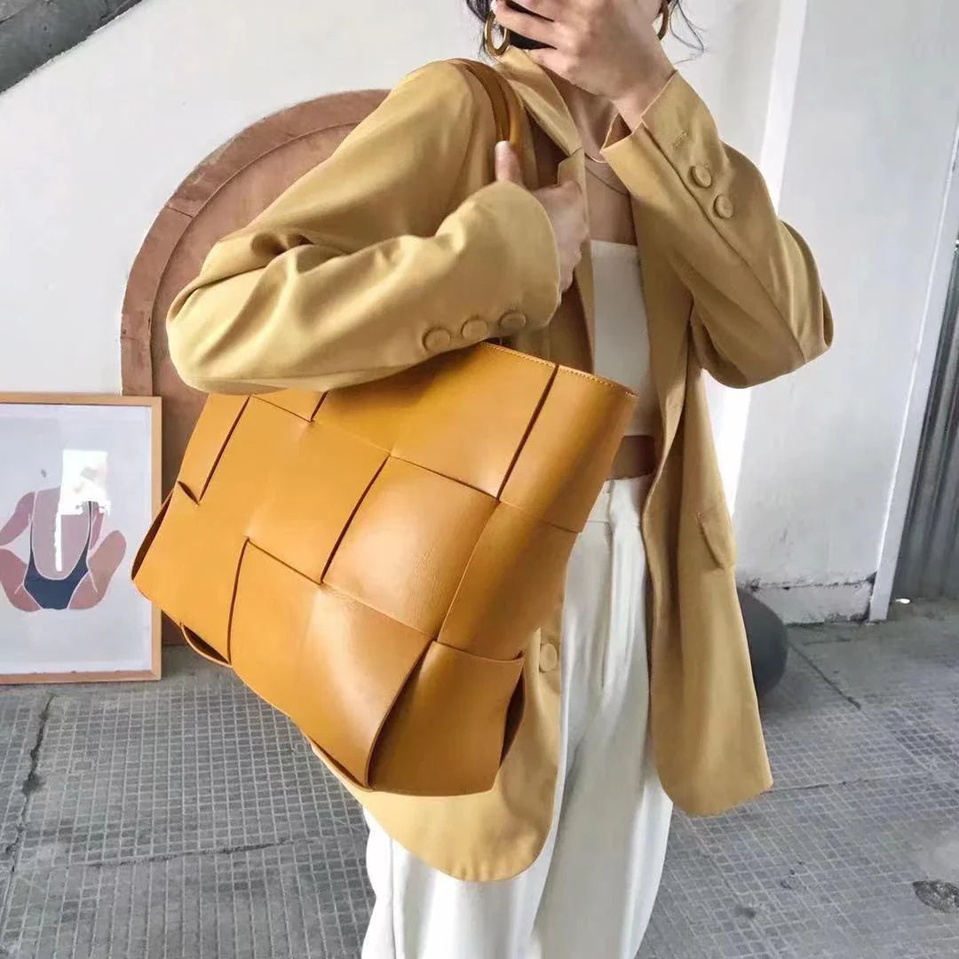 Exquisitely crafted leather tote bag with a timeless woven design, embodying British elegance and quality.