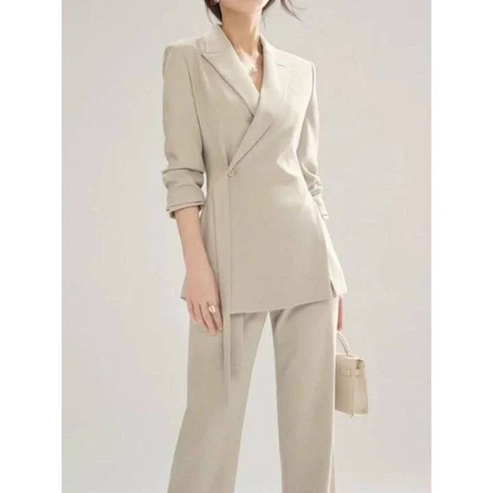 A two-piece vintage-inspired office suit with a long-sleeve blazer and high-waisted trousers, designed for the modern professional woman.