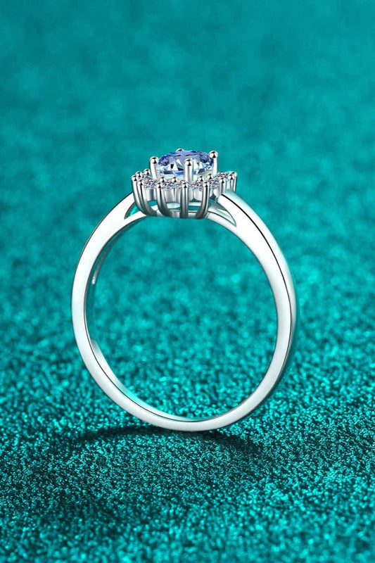 A close-up of a minimalist, polished 925 sterling silver ring with a dazzling moissanite centre stone
