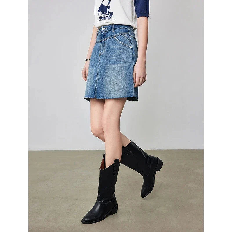 Sophisticated lyocell denim mini skirt with classic A-line silhouette and functional pockets for the discerning British woman