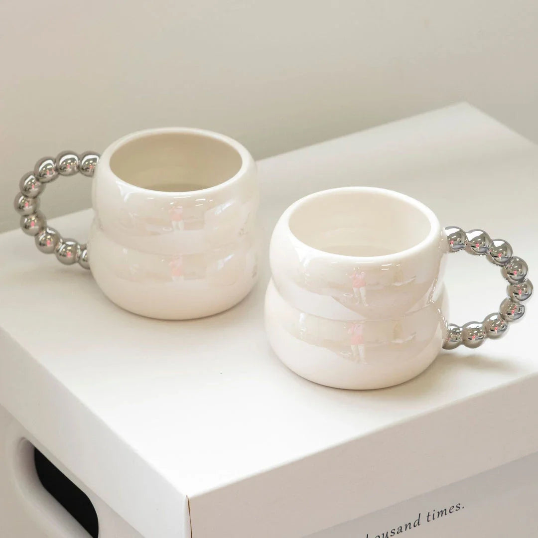 Handmade ceramic mug in beige and blue Nordic-inspired design, with a comfortable handle for enjoying hot or cold beverages.
