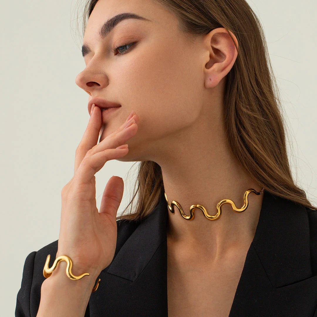 Elegant 18K gold-plated stainless steel wave bracelet and necklace set for women, showcasing a unique contemporary design with adjustable drawstring closure