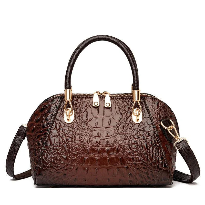 Premium leather one-shoulder messenger bag in various colours, featuring a sleek, shell-inspired silhouette and multiple internal pockets for organisation.