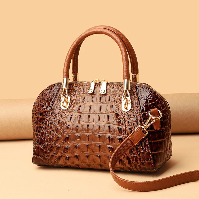 Premium leather one-shoulder messenger bag in various colours, featuring a sleek, shell-inspired silhouette and multiple internal pockets for organisation.