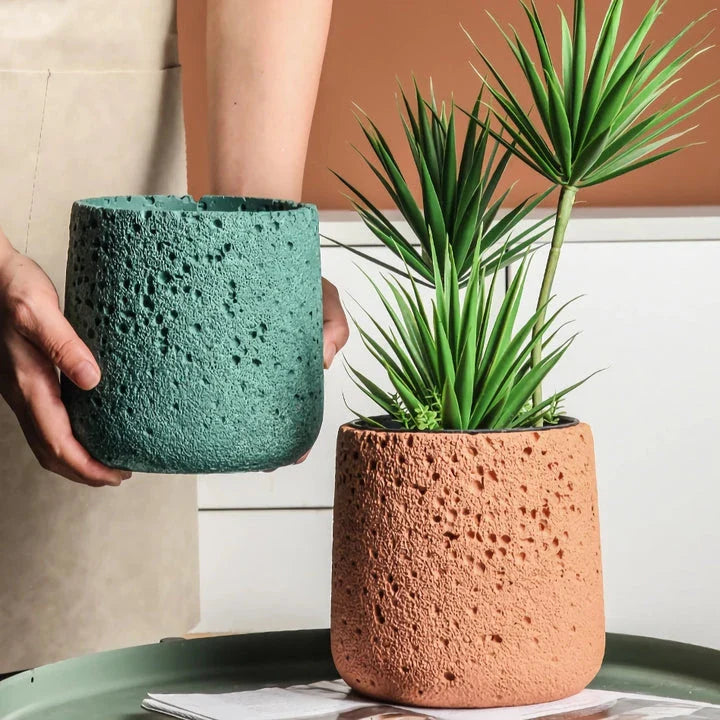 A modern, perforated cement bonsai planter in a Nordic-inspired design, available in various sizes and colours.