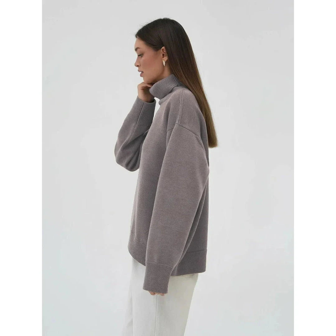 Cosy oversized knitted pullover in blue, featuring a classic turtleneck collar and drop-shoulder silhouette for maximum comfort and style.