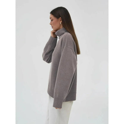 Cosy oversized knitted pullover in blue, featuring a classic turtleneck collar and drop-shoulder silhouette for maximum comfort and style.