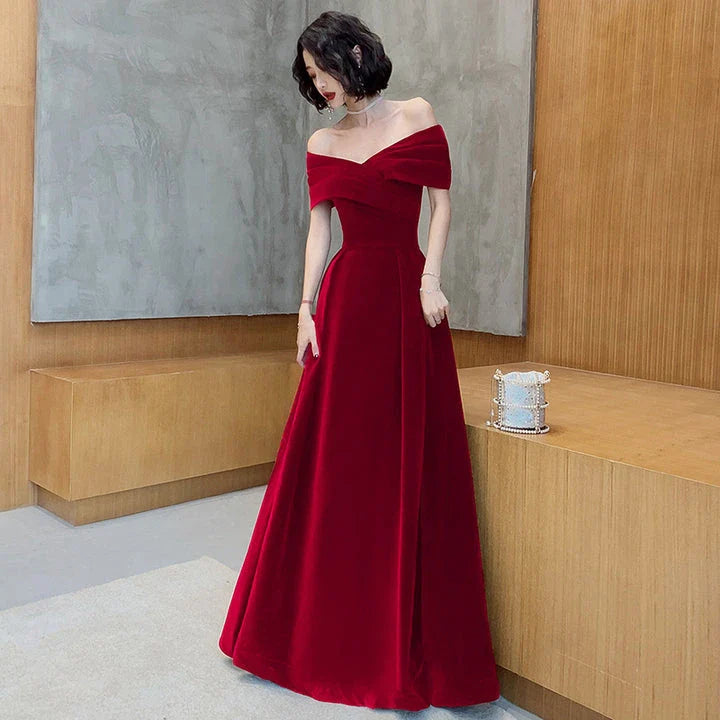 Off-shoulder wine red bridal dress with long, flowing skirt and tight waist for a sophisticated, elegant look