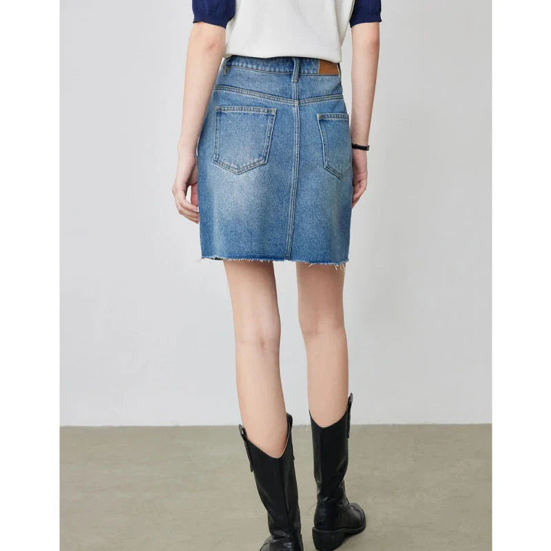 Sophisticated lyocell denim mini skirt with classic A-line silhouette and functional pockets for the discerning British woman