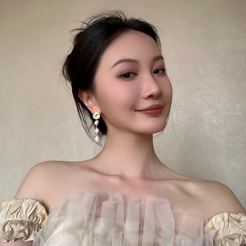 Elegant pearl and gold plated earrings with a long, eye-catching design