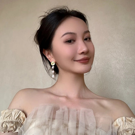 Elegant pearl and gold plated earrings with a long, eye-catching design