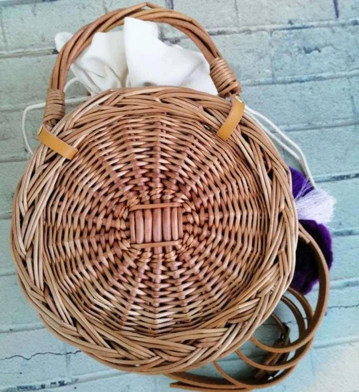 Elegant handcrafted rattan basket handbag with floral design, showcasing traditional British craftsmanship and modern sophistication