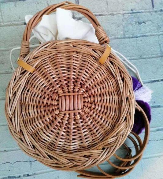 Elegant handcrafted rattan basket handbag with floral design, showcasing traditional British craftsmanship and modern sophistication