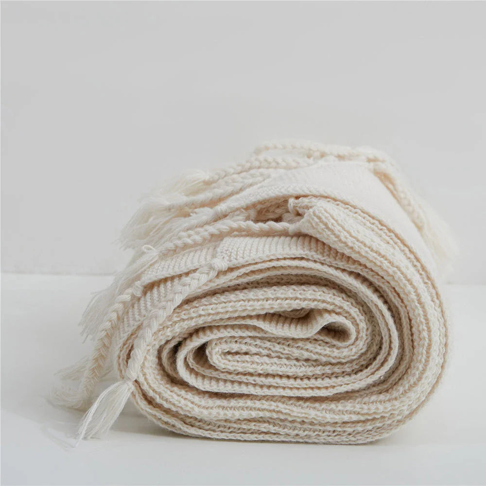 Luxurious Nordic-style wool knitted throw blanket in grey colour, featuring a solid pattern and elegant tassel design