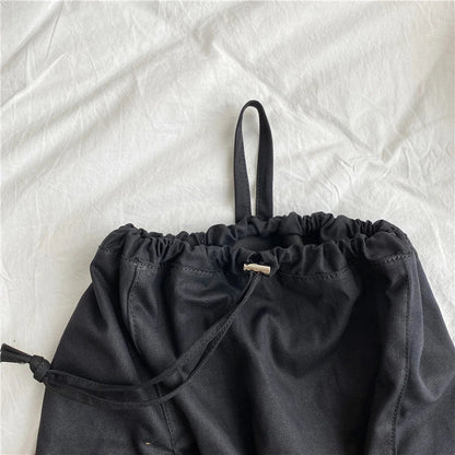 A stylish drawstring bucket bag in white, black, or brown colour options, featuring a spacious interior and adjustable closure for modern British women.