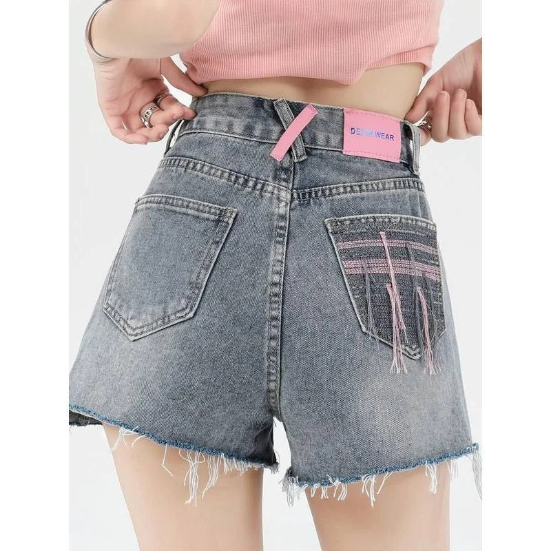Stylish high-waisted denim shorts with subtle embroidery, perfect for summer fashion