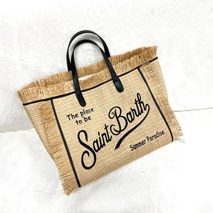 Stylish embroidered straw tote bag with playful tassels, perfect for summer outings and beach adventures.