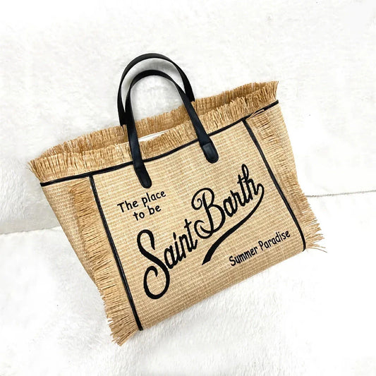 Stylish embroidered straw tote bag with playful tassels, perfect for summer outings and beach adventures.