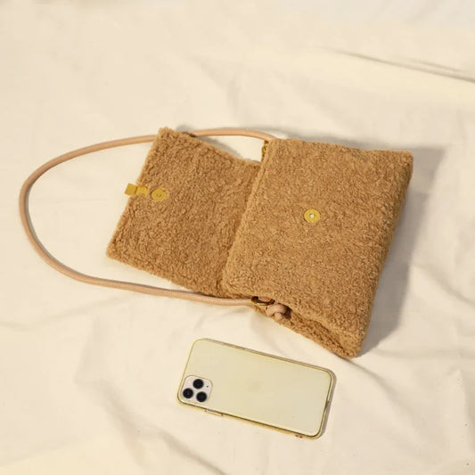 A stylish faux lamb wool crossbody bag in beige, black, or khaki brown with a contemporary design and practical storage features