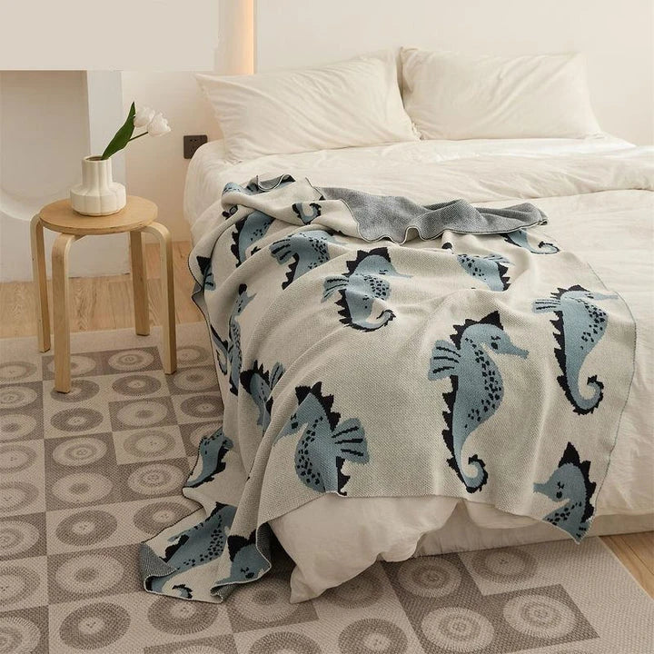 Soft and cosy 100% cotton blanket with a charming sea horse design, perfect for relaxation at home or on the go.