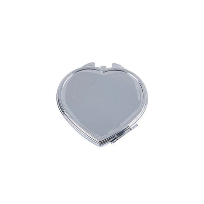 Elegant heart-shaped metal pill box with mirror for organized storage and convenient touch-ups