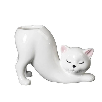 A white ceramic flower pot with a playful cartoon cat design and a functional tail element, perfect for desktops and small spaces.