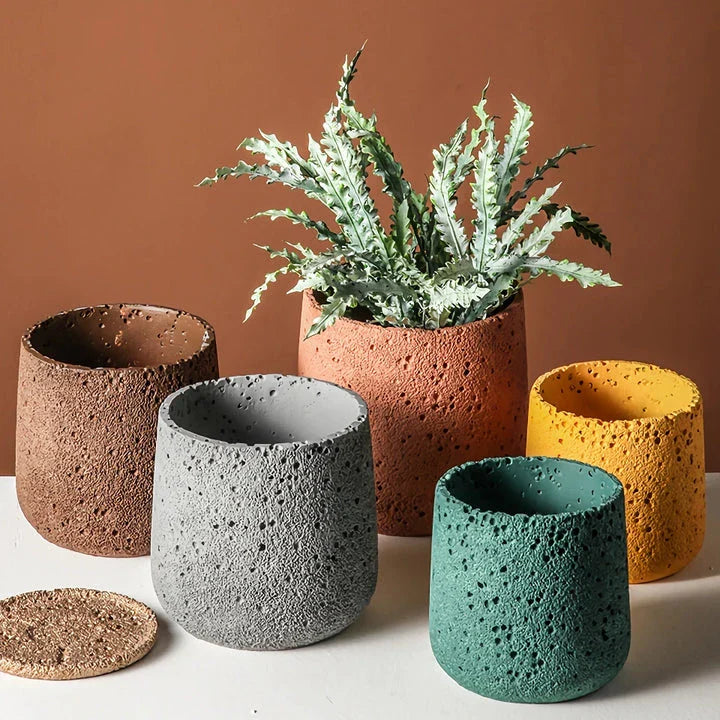 A modern, perforated cement bonsai planter in a Nordic-inspired design, available in various sizes and colours.