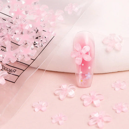 Elegant 3D flower nail charms in white and pink colours, featuring a transparent jelly finish and rhinestone accents for a stylish manicure