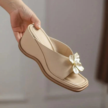 Elegant pearl flower wedge sandals in beige colour, featuring a thick, cushioned platform and adjustable straps for a comfortable fit.