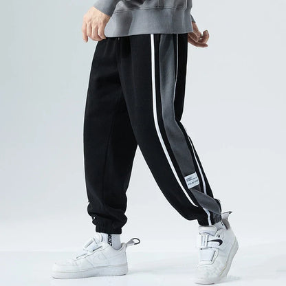 Plus-size men's loose sports trousers with ankle ties, made of premium polyester fabric in classic colours for versatile, comfortable activewear.