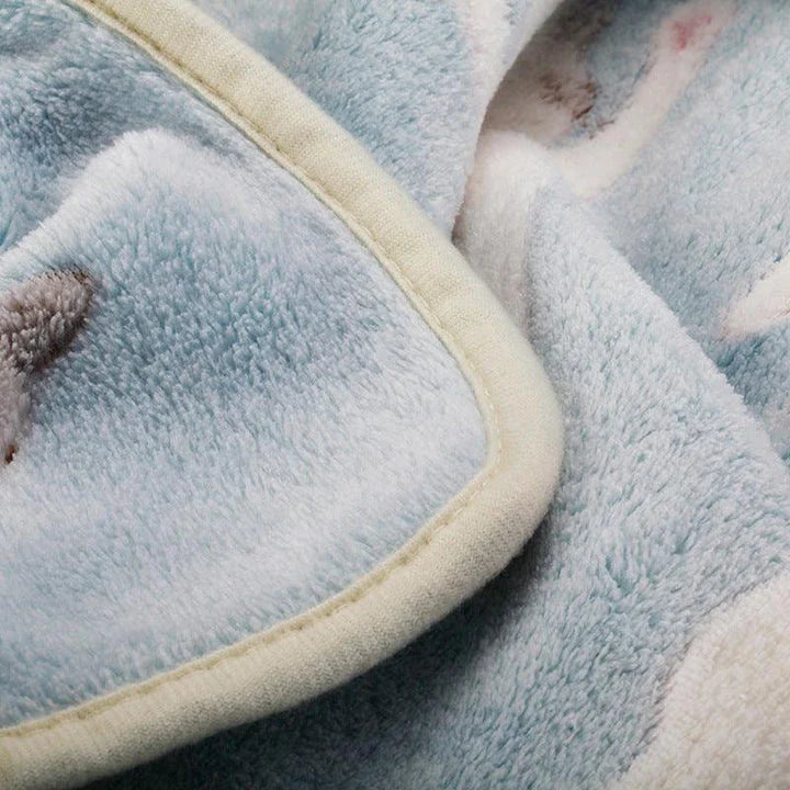 A large, soft, and cosy fleece blanket in a light blue colour, perfect for snuggling up on a bed or sofa
