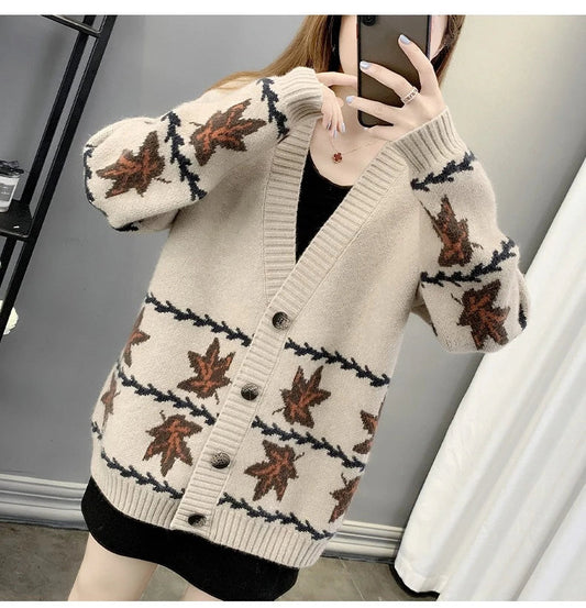 A cosy, loose-fitting women's cardigan sweater with a jacquard knitted maple leaf pattern in a range of neutral colours