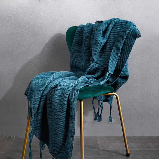Luxurious Nordic-style wool knitted throw blanket in grey colour, featuring a solid pattern and elegant tassel design