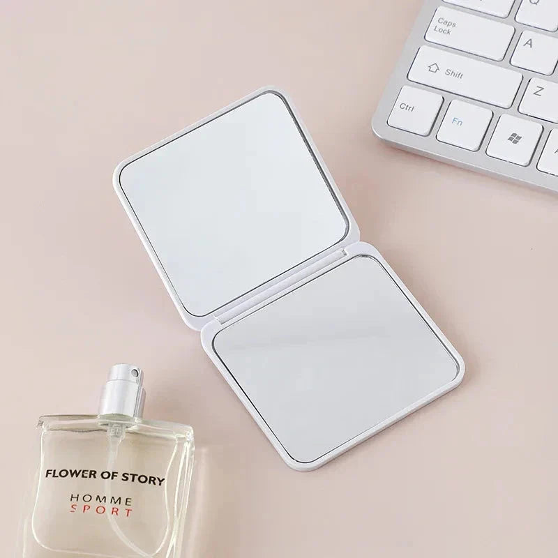 Compact double-sided makeup mirror in multiple vibrant colours, featuring a foldable design for easy portability