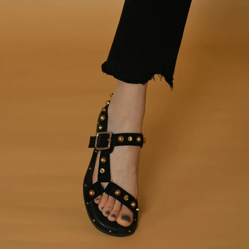 Black flat sandals with orange accents, inspired by the Roman Holiday style, suitable for women