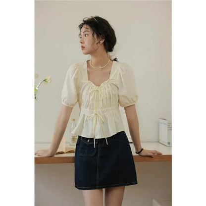 Elegant vintage-inspired blouse with square neckline, puff sleeves, and lace-up details for a timeless, sophisticated look