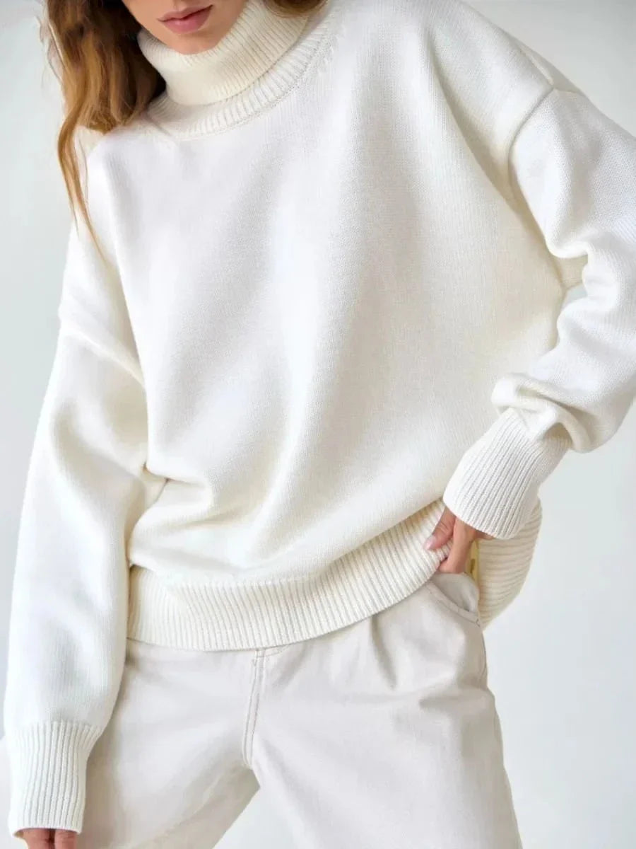Cosy oversized knitted pullover in blue, featuring a classic turtleneck collar and drop-shoulder silhouette for maximum comfort and style.