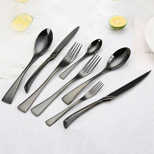 A stylish set of black stainless steel flatware, including a teaspoon, knife, and fork, on a white background.