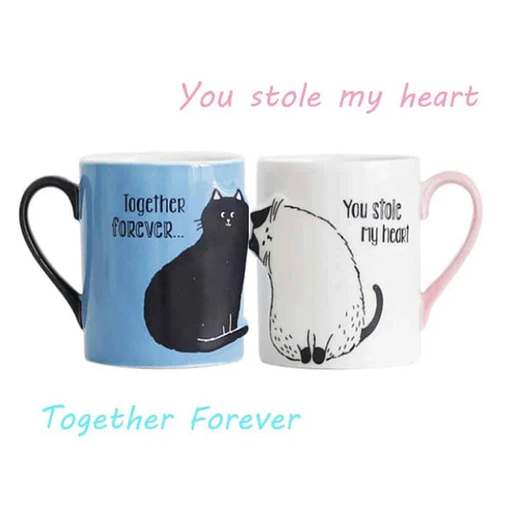 A pair of ceramic mugs featuring a charming design of two kissing cats, perfect for couples and cat lovers