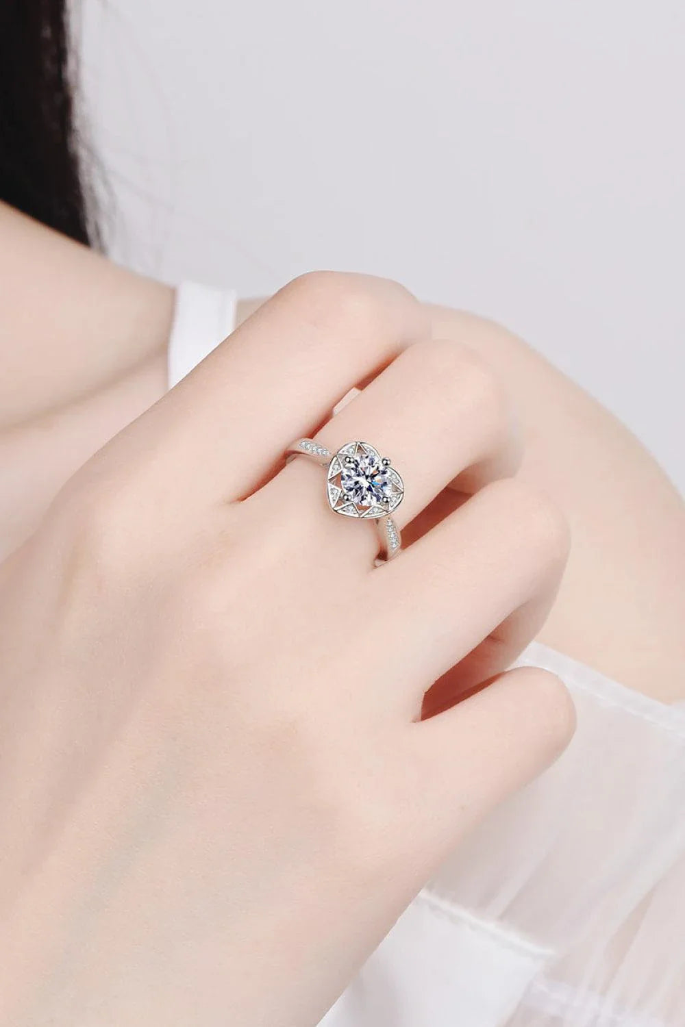 Elegant moissanite heart-shaped ring in sterling silver setting with zircon accent stones