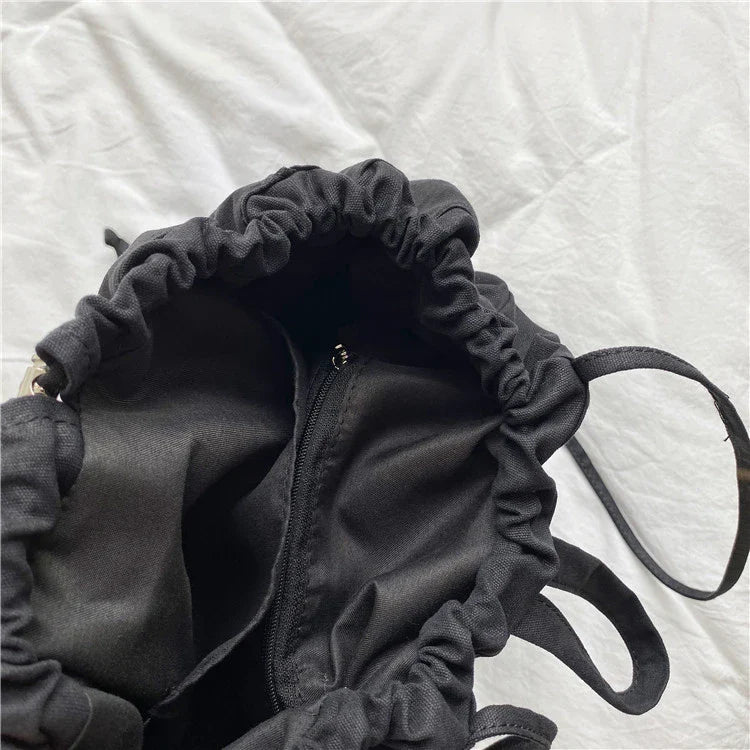 A stylish drawstring bucket bag in white, black, or brown colour options, featuring a spacious interior and adjustable closure for modern British women.