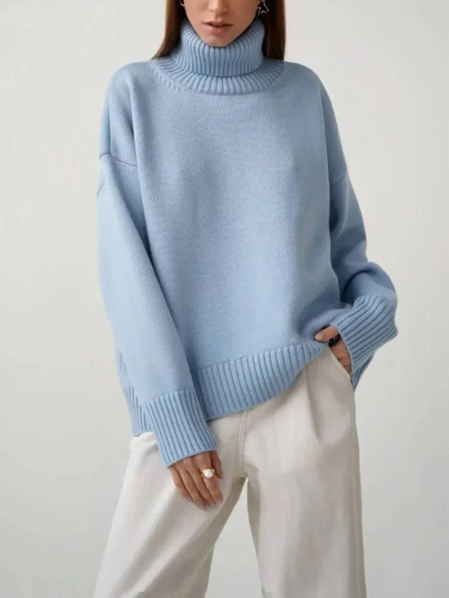 Cosy oversized knitted pullover in blue, featuring a classic turtleneck collar and drop-shoulder silhouette for maximum comfort and style.