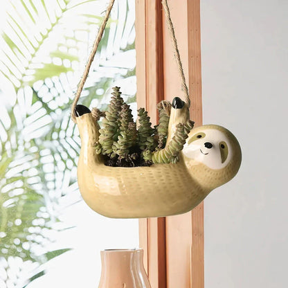 Ceramic hanging planter with a whimsical cartoon animal design, available in grey or yellow, for adding a touch of nature and playfulness to indoor spaces.